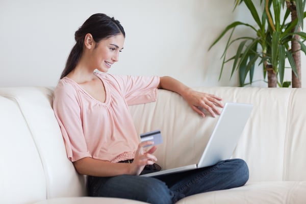 Delighted woman shopping online in her living room