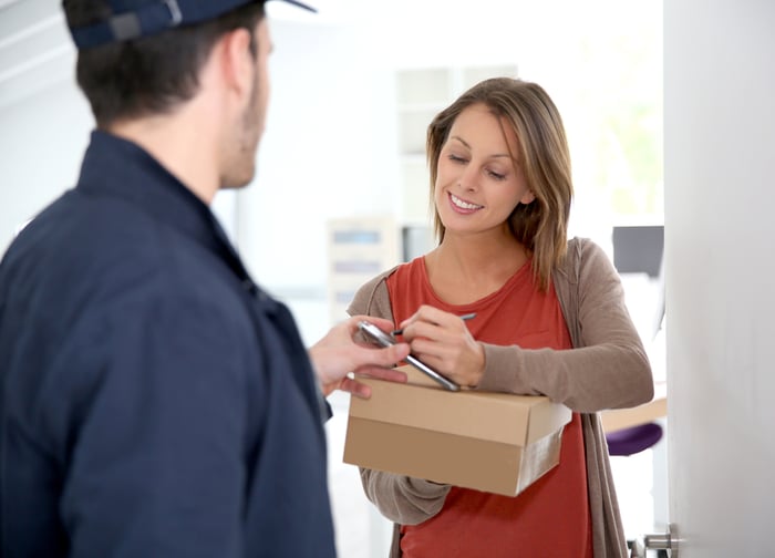 Woman sigining electronic receipt of delivered package-1