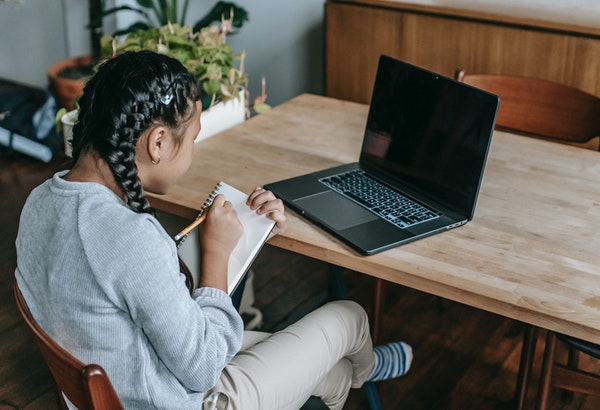 estudiante haciendo su tarea y clases en casa de manera virtual