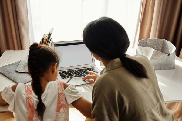una mamá ayudando a su hija a elaborar la tarea