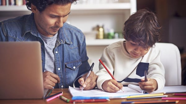 un papa ayuando a su hijo a realizar la tarea